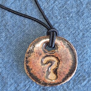 circular pendant with copper glaze and imprinted question mark