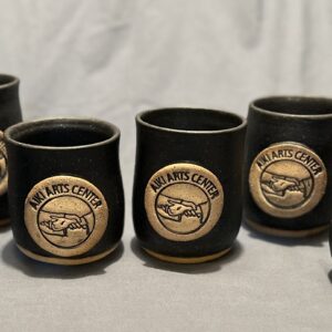 line of black cups with aiki arts center logo in center